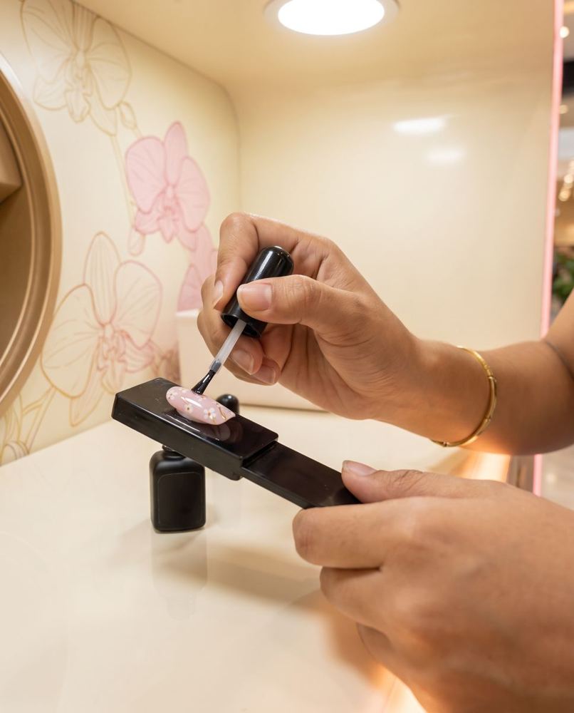 Pincel aplicando gel sobre una uña impresa